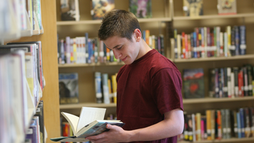 Teen exploring books in library